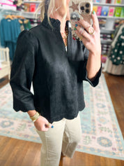 Black faux suede top with mock neck, gathered front, and scalloped hem