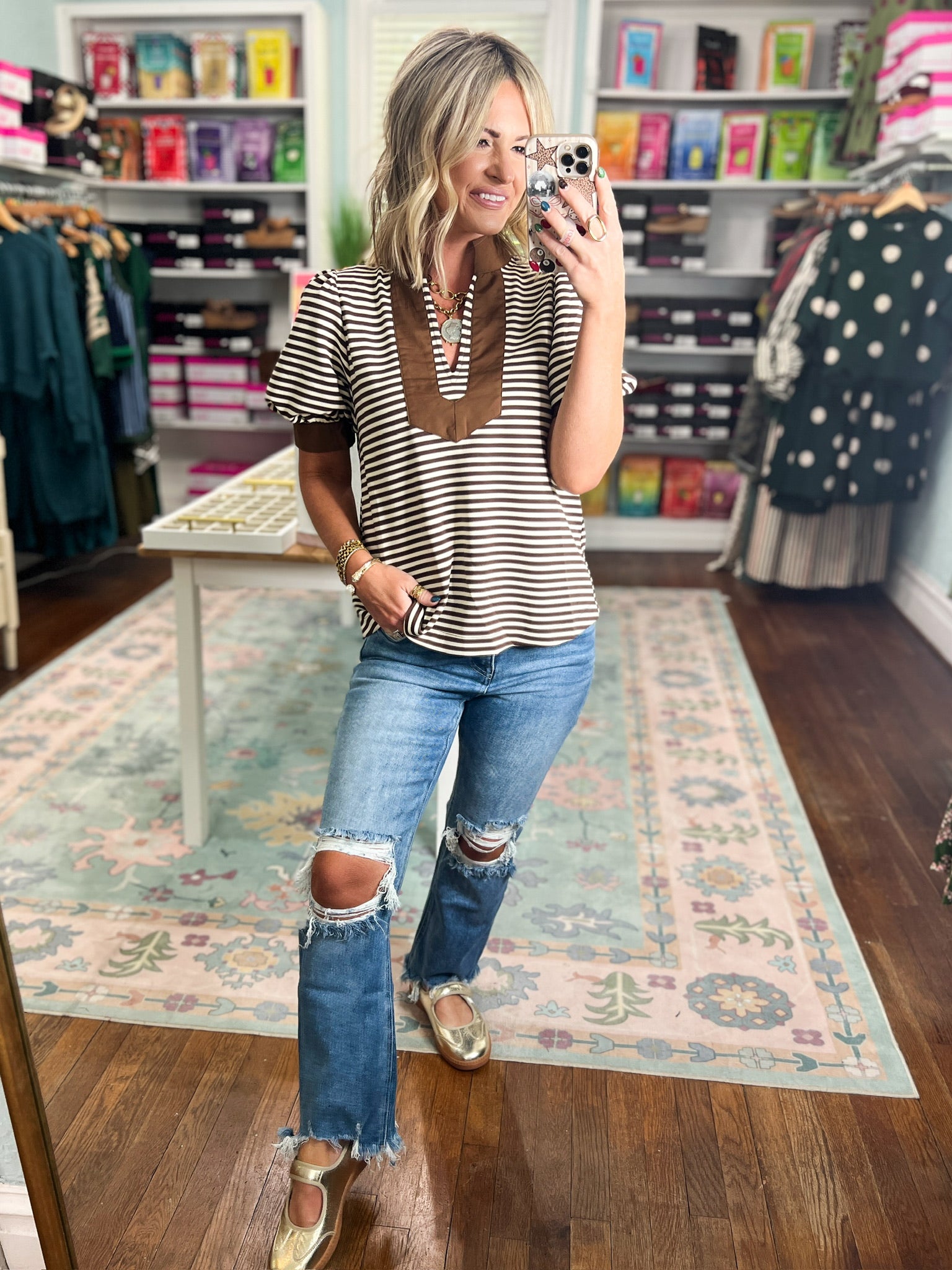 Striped short sleeve V-neck top with brown neckline trim, angled side view
