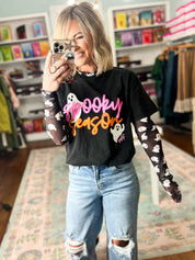 Black long-sleeve graphic top with colorful cartoon print, crew neck