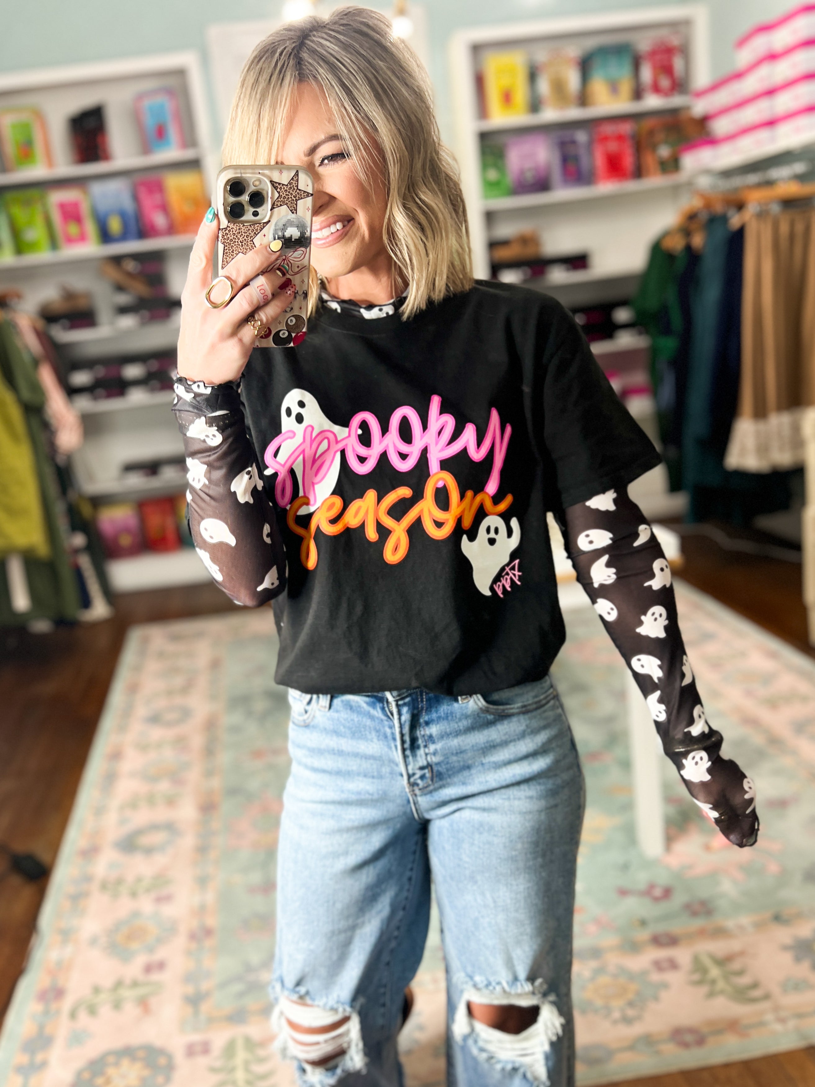 Black long-sleeve graphic top with colorful cartoon print, crew neck