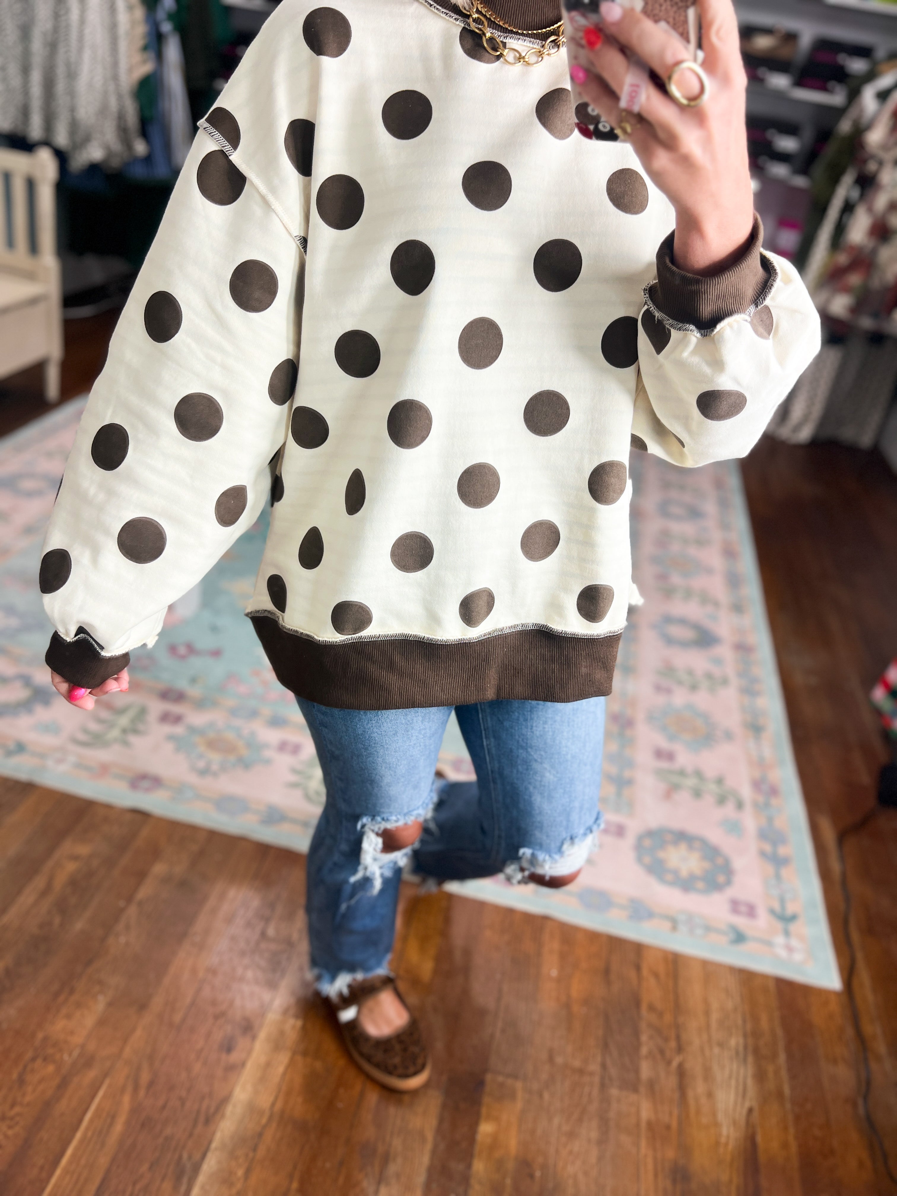 Reversible mock neck sweatshirt close-up: ivory polka dot sleeves with dark cuff