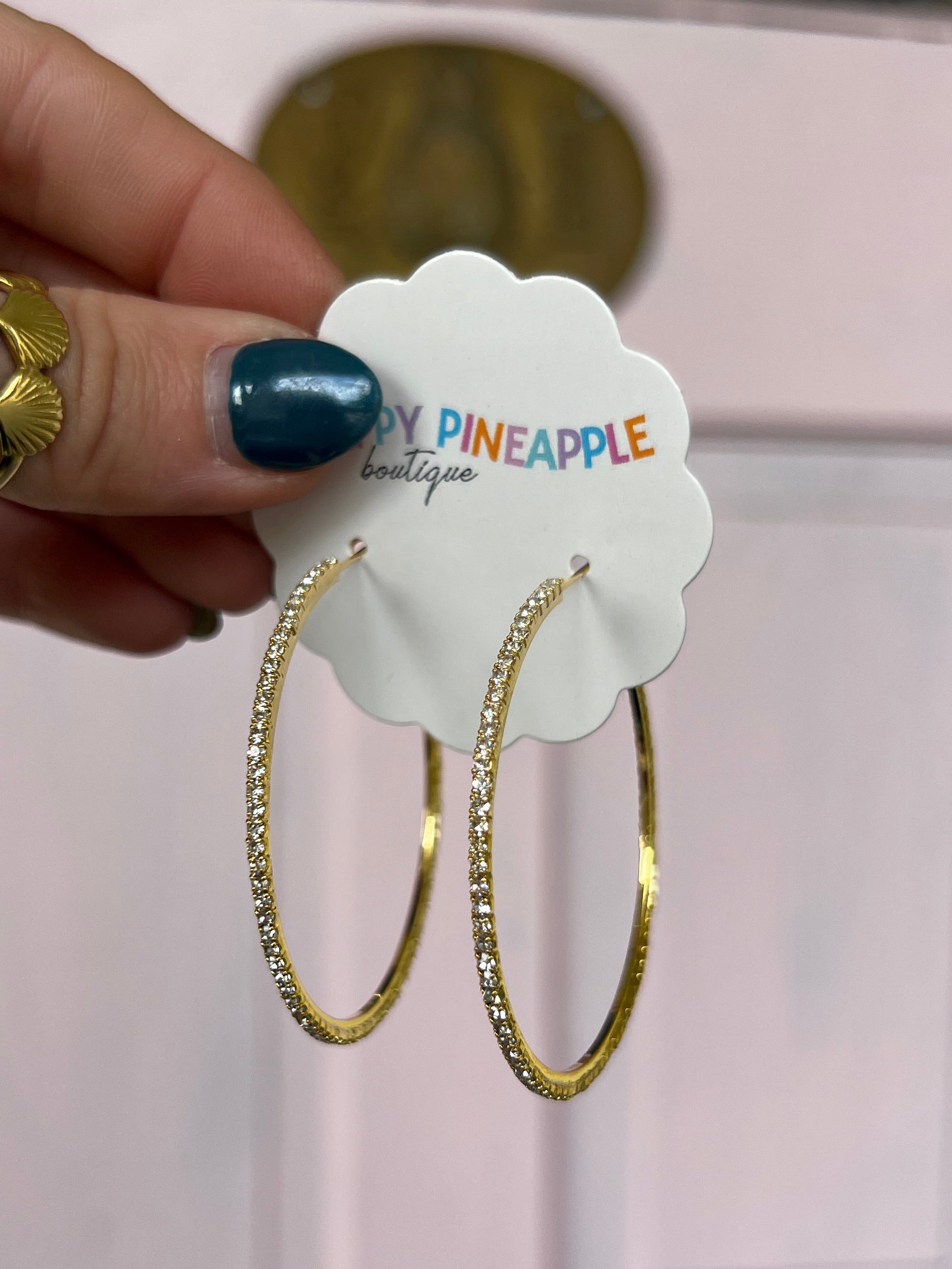 Gold pavé crystal hoop earrings on display card