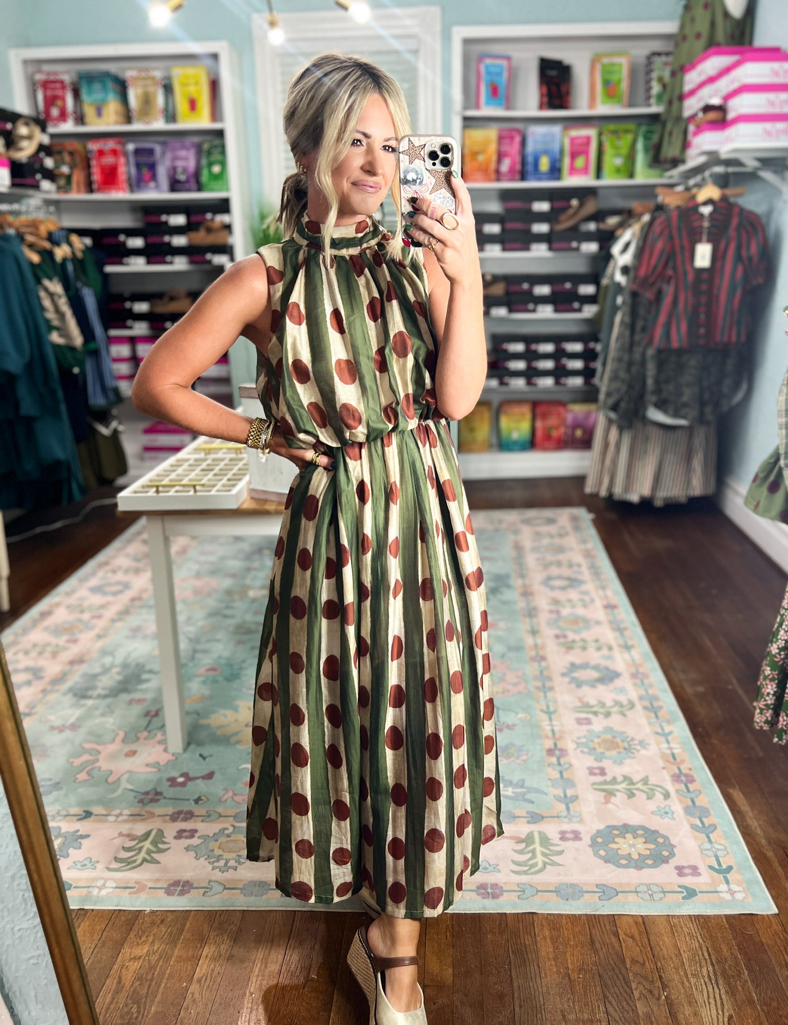 Front view: green sleeveless midi dress with red polka dots and flowing skirt