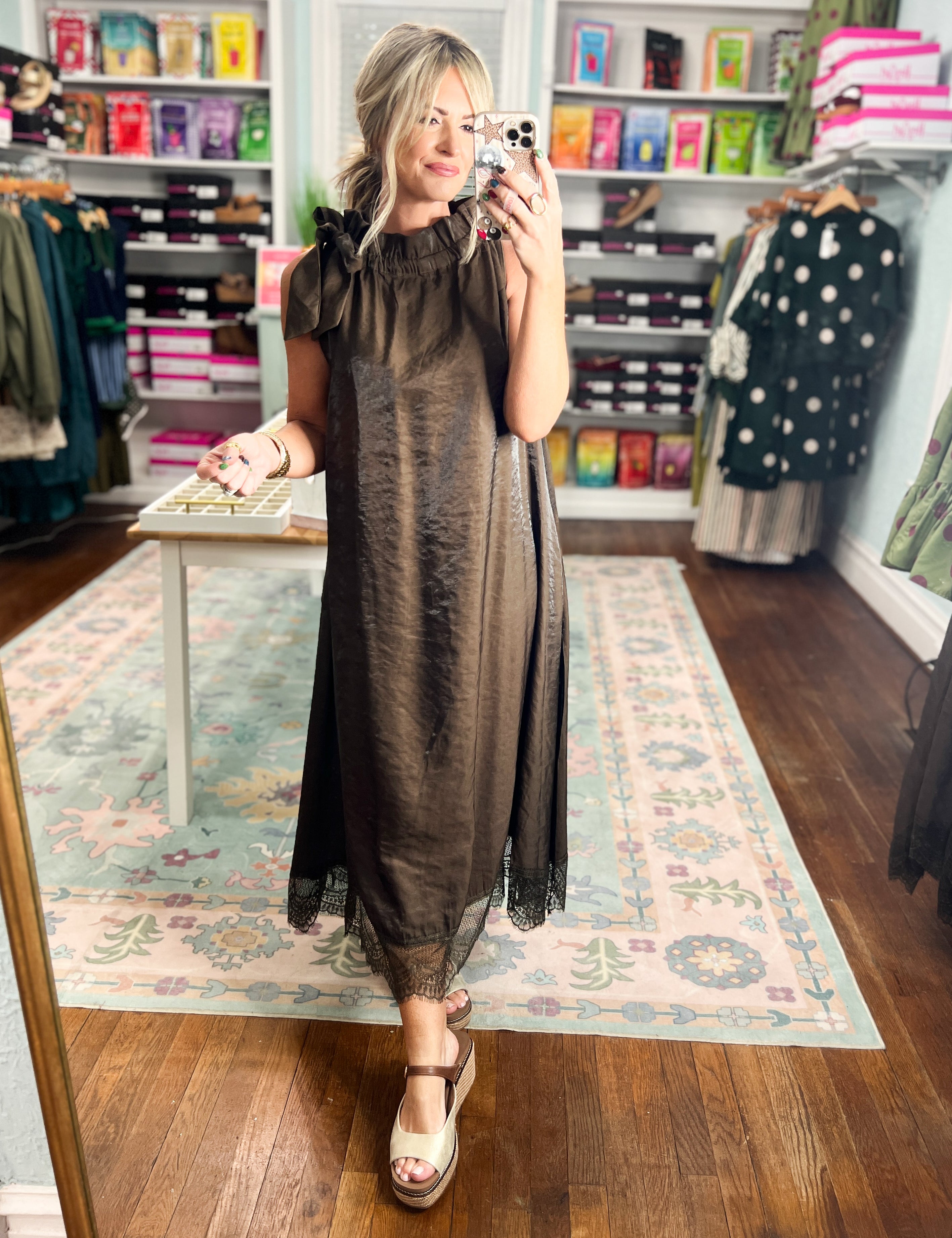 Brown sleeveless midi dress with ruffled collar, bow straps, and lace-edged hem.