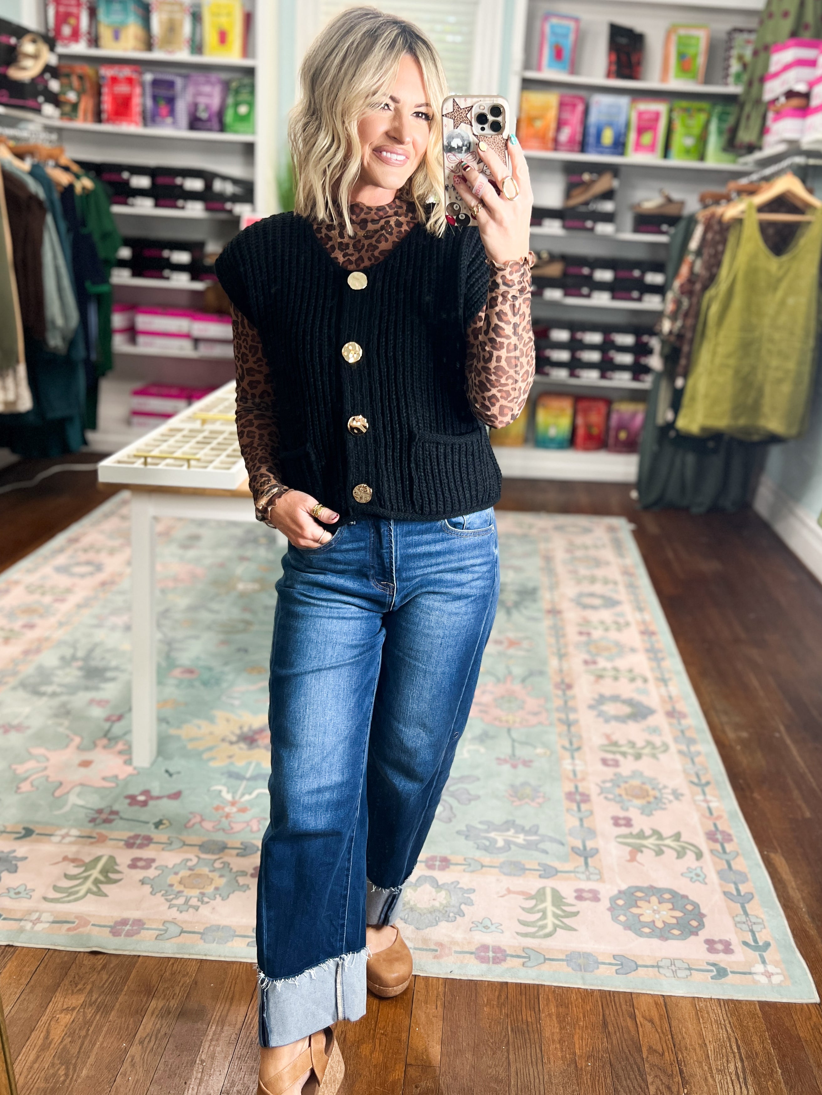 Black knit sweater vest with front pockets and gold button closure