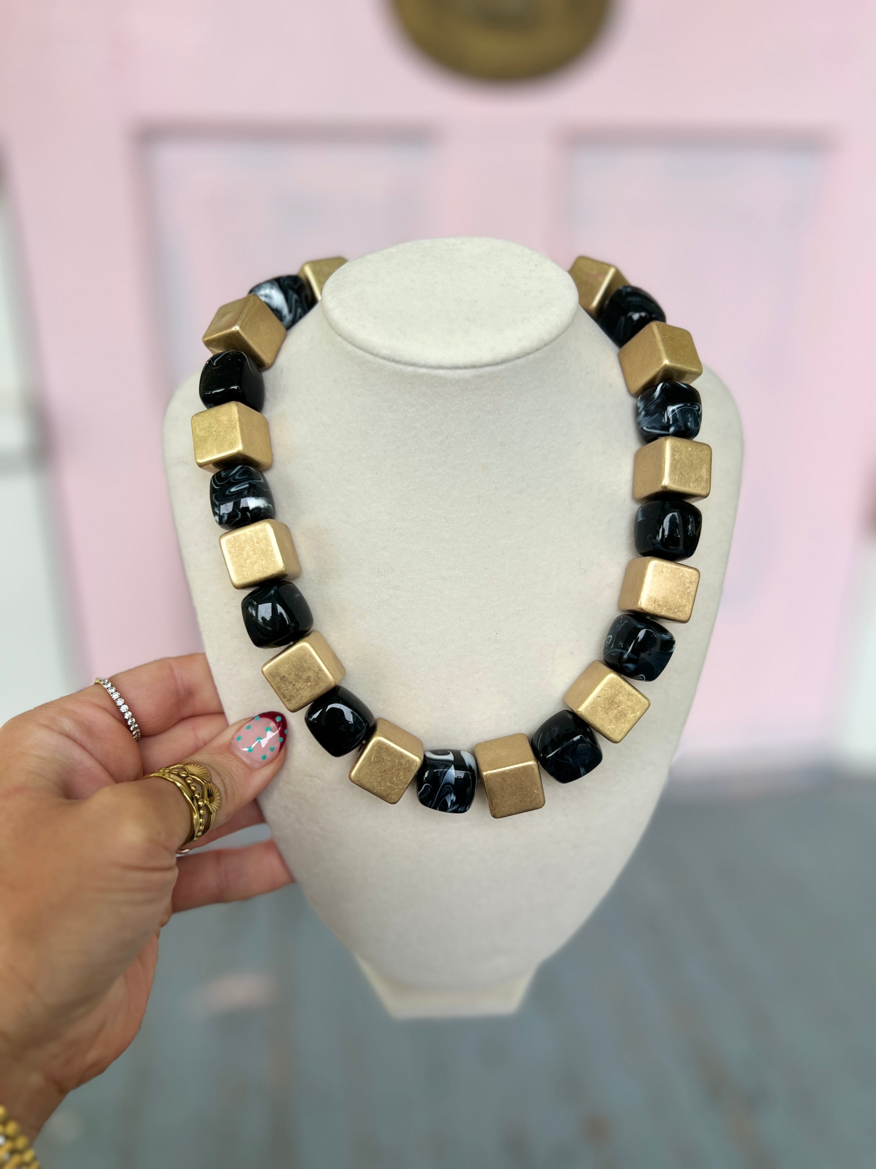 Bead necklace with gold-tone metal cubes and black acrylic bead segments