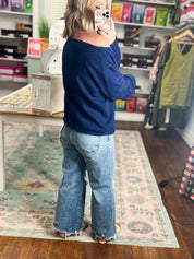 Navy off-shoulder sweater with long sleeves and relaxed shoulder line