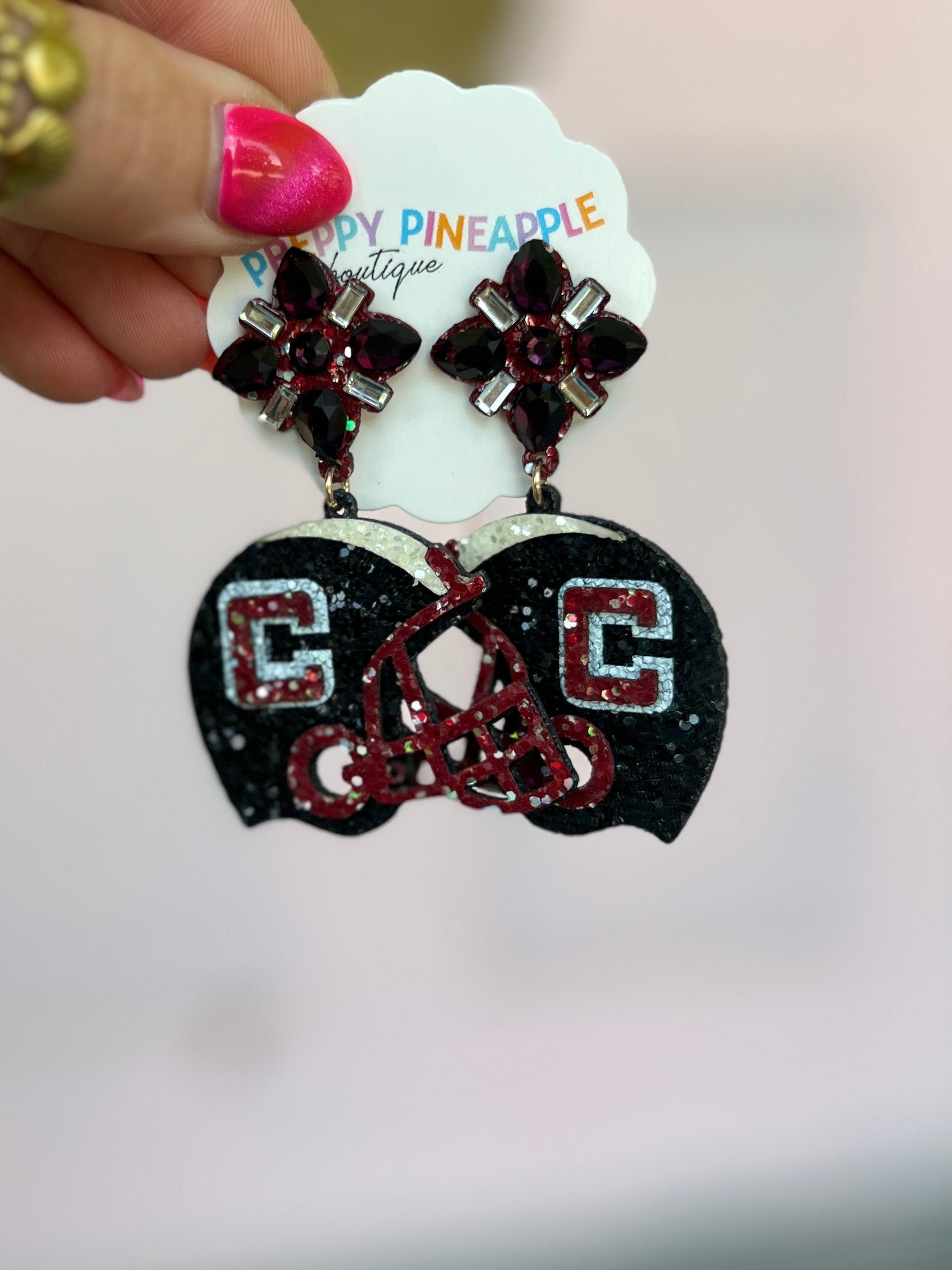 Glitter black helmet-shaped drop earrings with red bead accents and crystal studs