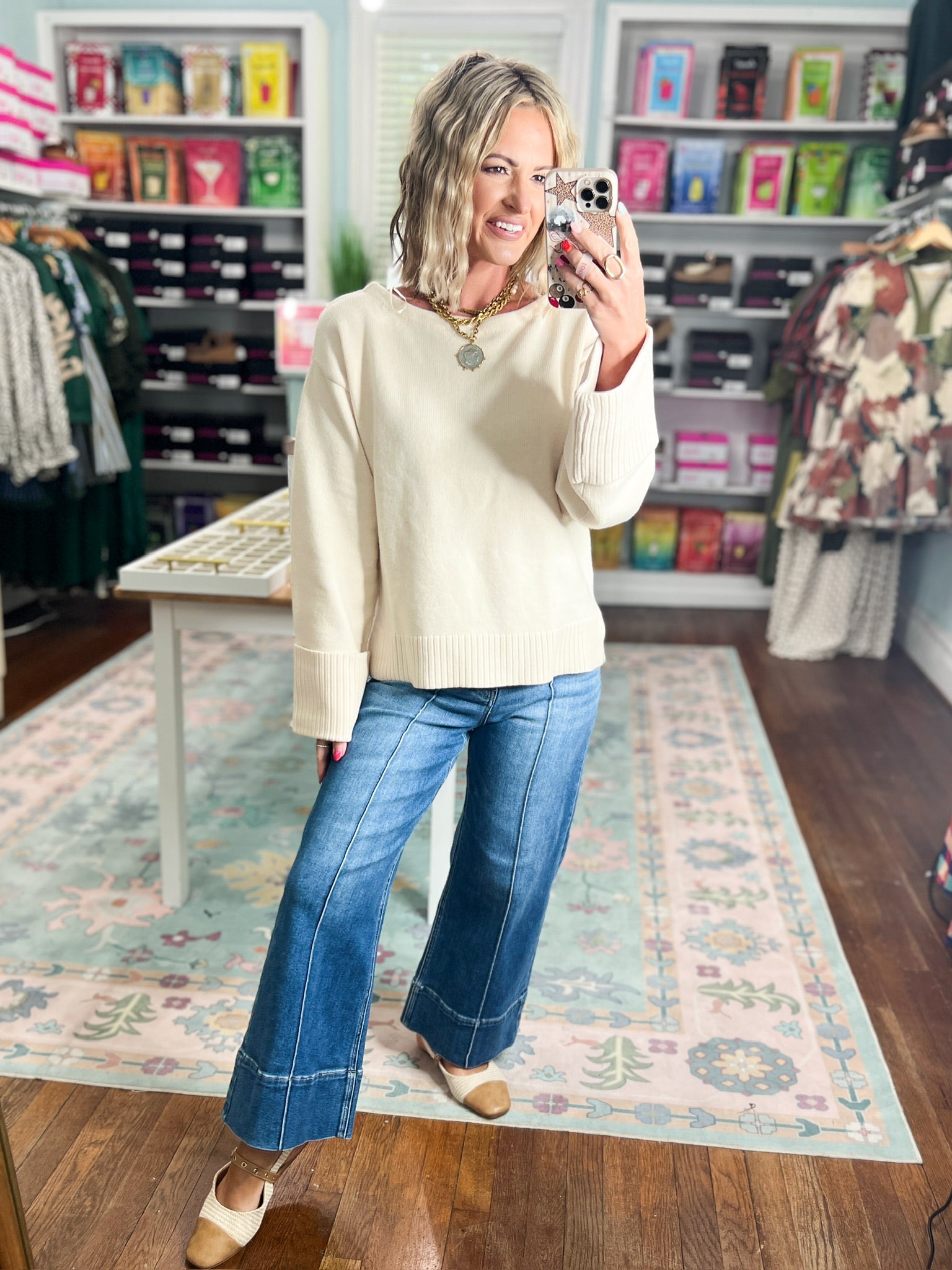 Ecru wide-sleeve knit sweater with ribbed cuffs and hem, worn with blue jeans.
