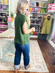 Army green ribbed knit sweater, short sleeves, and gold buttons at front
