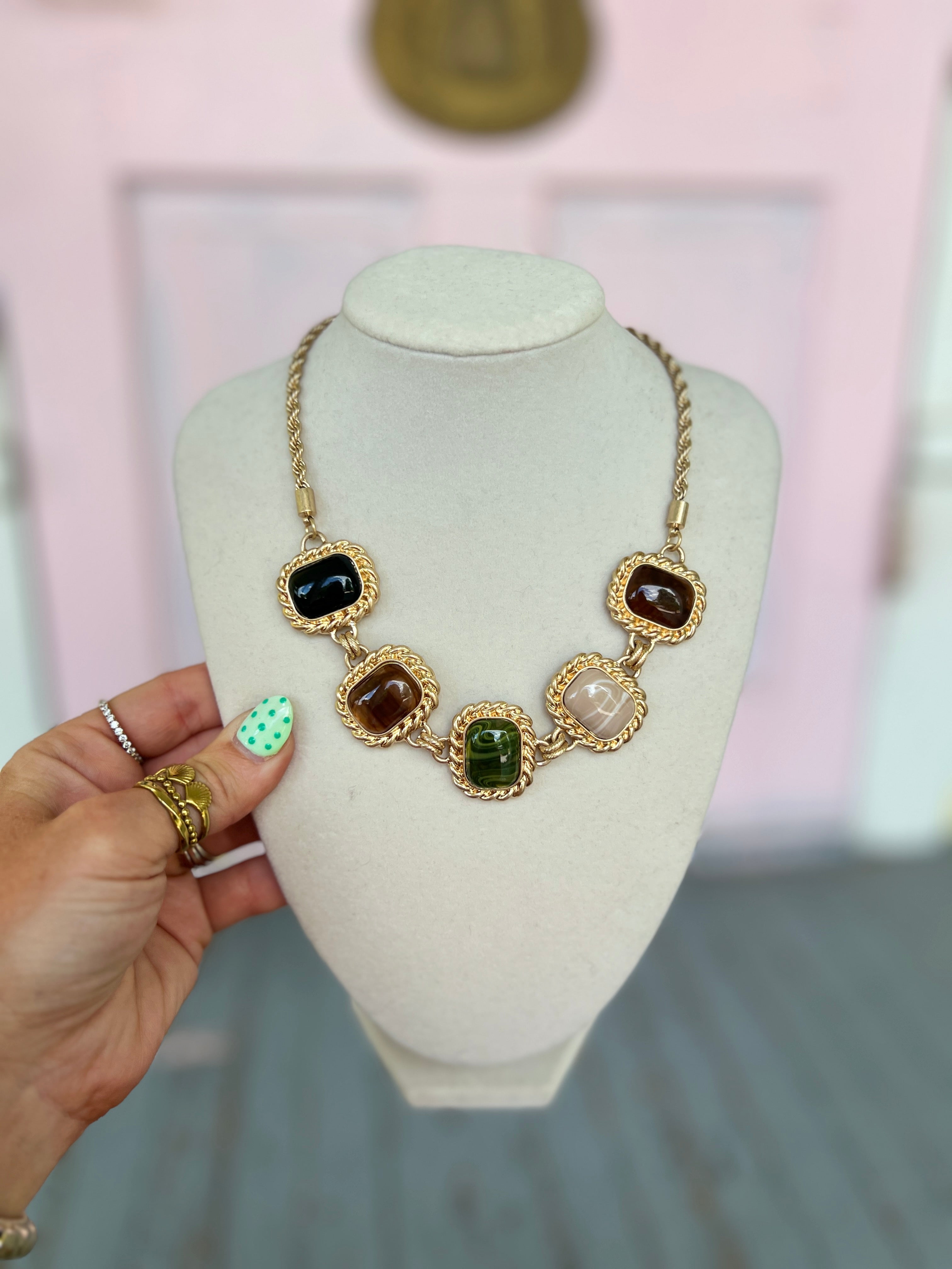 Gold framed square stone necklace with multicolor pendants, including black, brown, green, and teal