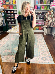 Olive patterned twill overalls with bib front, wide legs, and shoulder straps