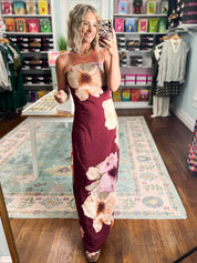 Burgundy strapless maxi dress featuring bold cream and pink floral bouquets on a slim fit