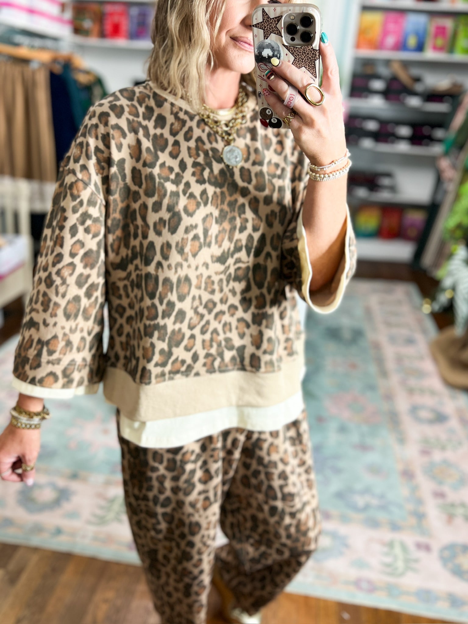 Loose animal-print top with three-quarter sleeves and ecru hem trim, shown from the front