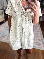Dotted mini dress detail: short sleeves, belted waist tie, buttoned front placket