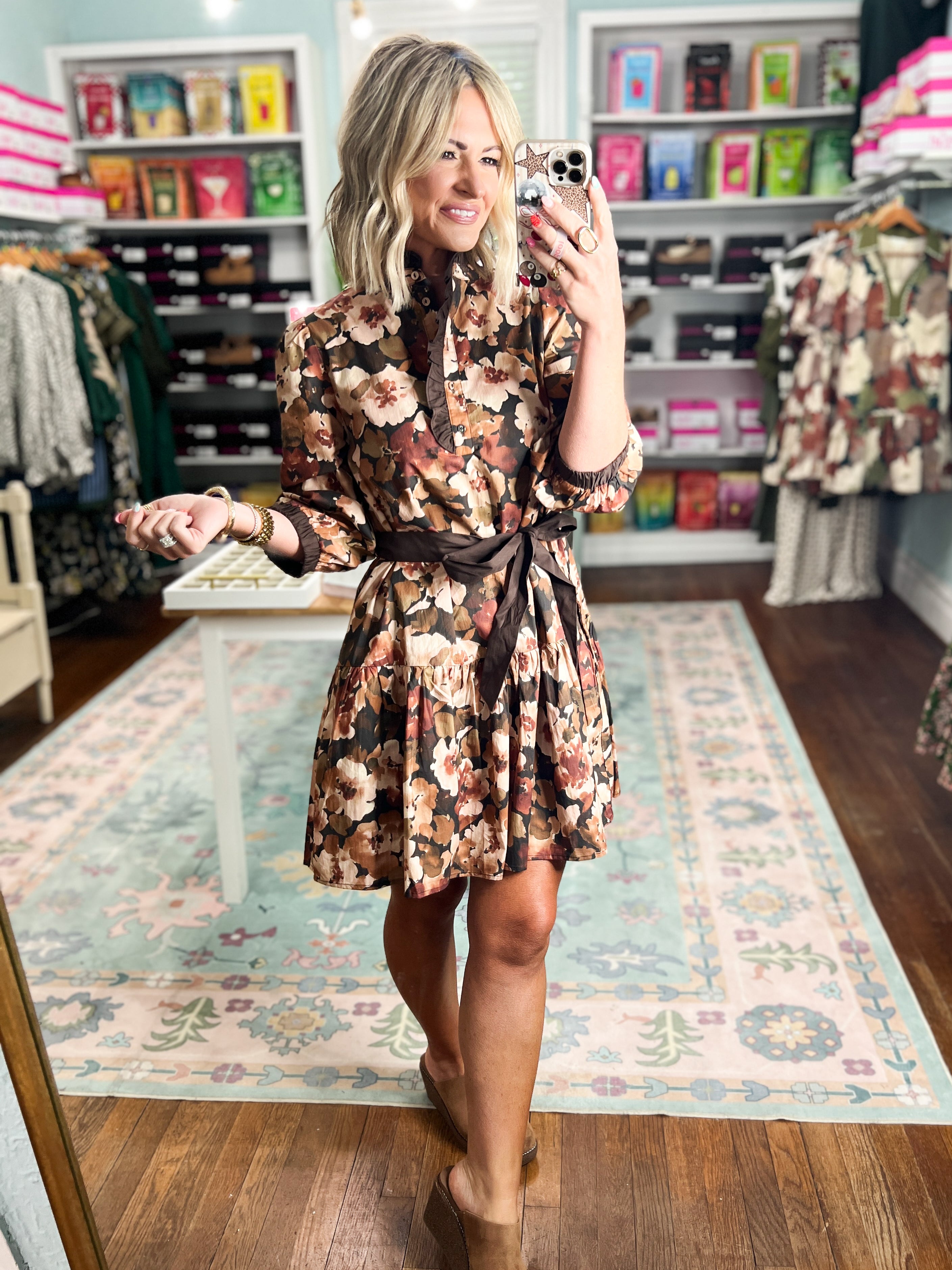 Floral print dress with long sleeves, tiered skirt, and tie waist, black background