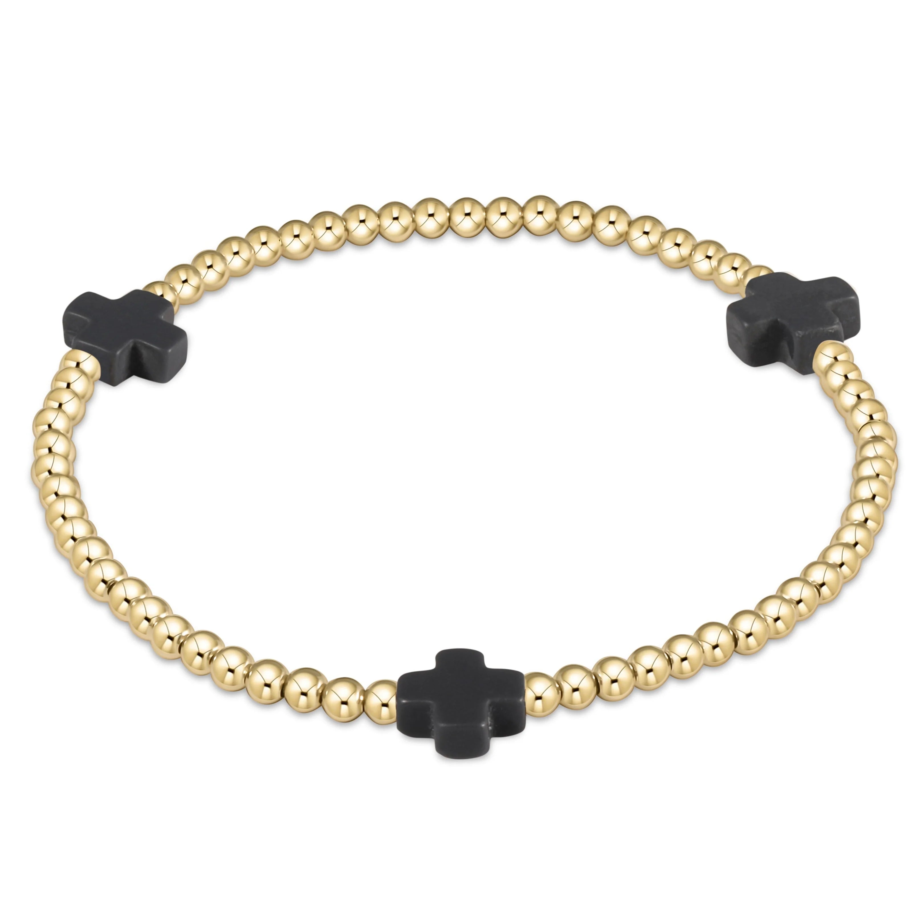 Gold beaded bracelet with three charcoal cross charms and a center cross