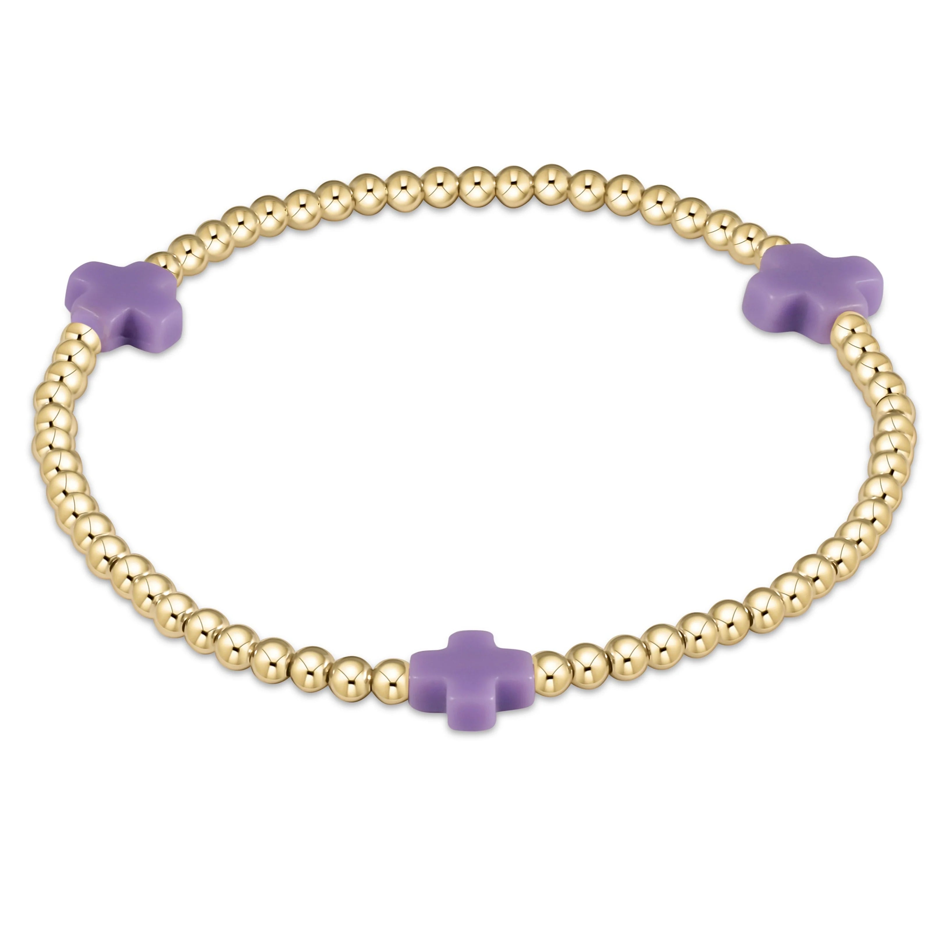 Gold bead bracelet with purple cross charms
