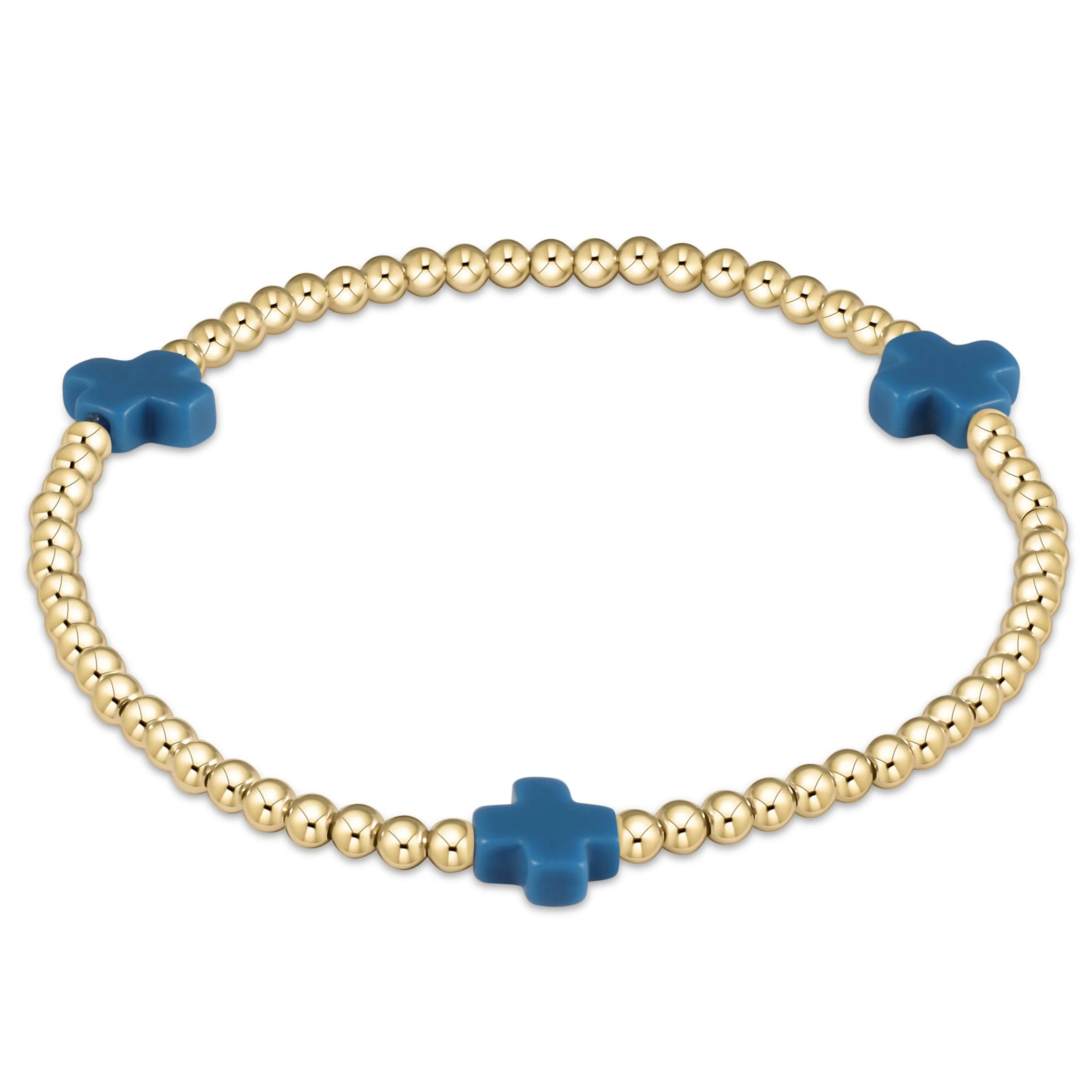 Gold bead bracelet with blue cross charms