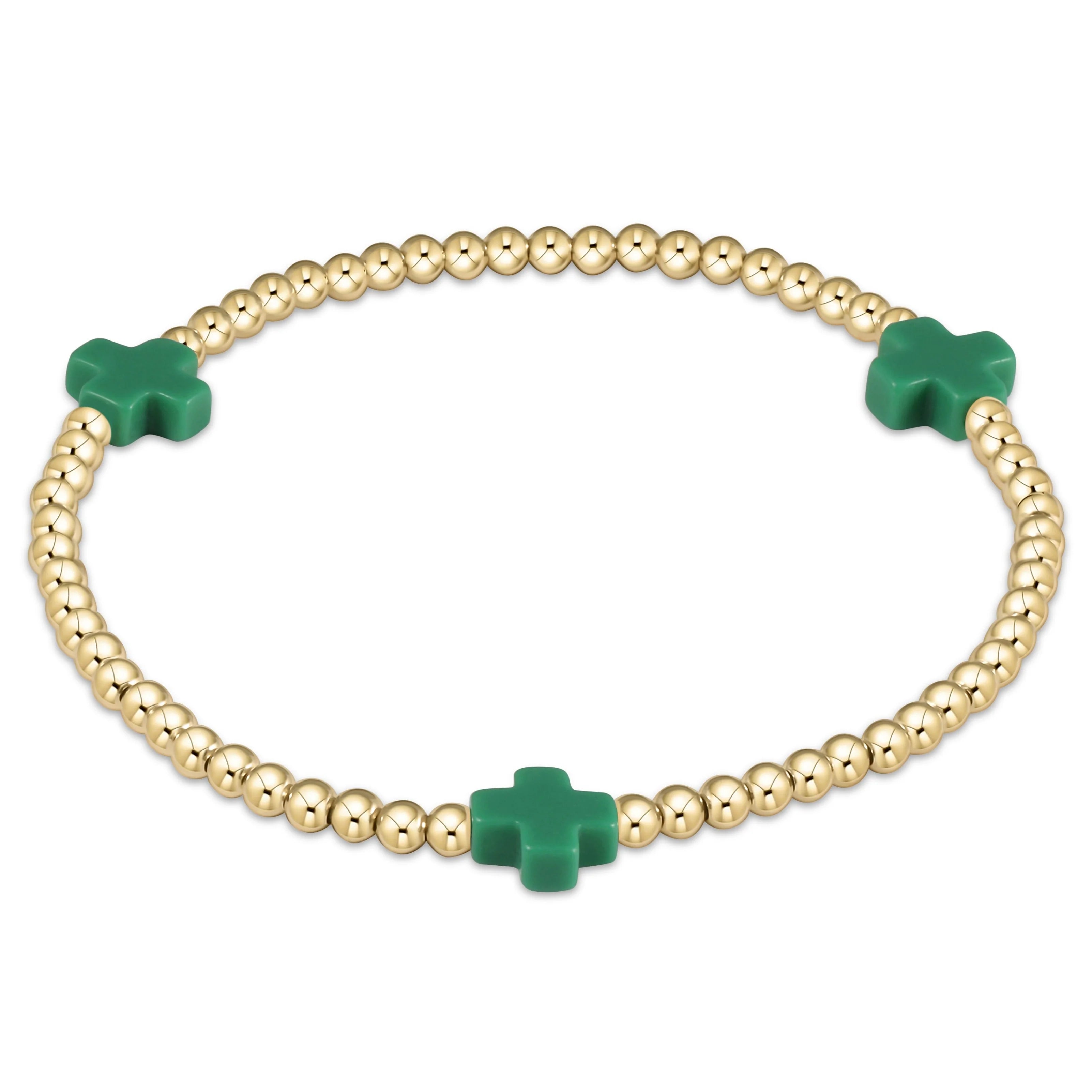 Gold bead bracelet with three green cross charms and ball chain links
