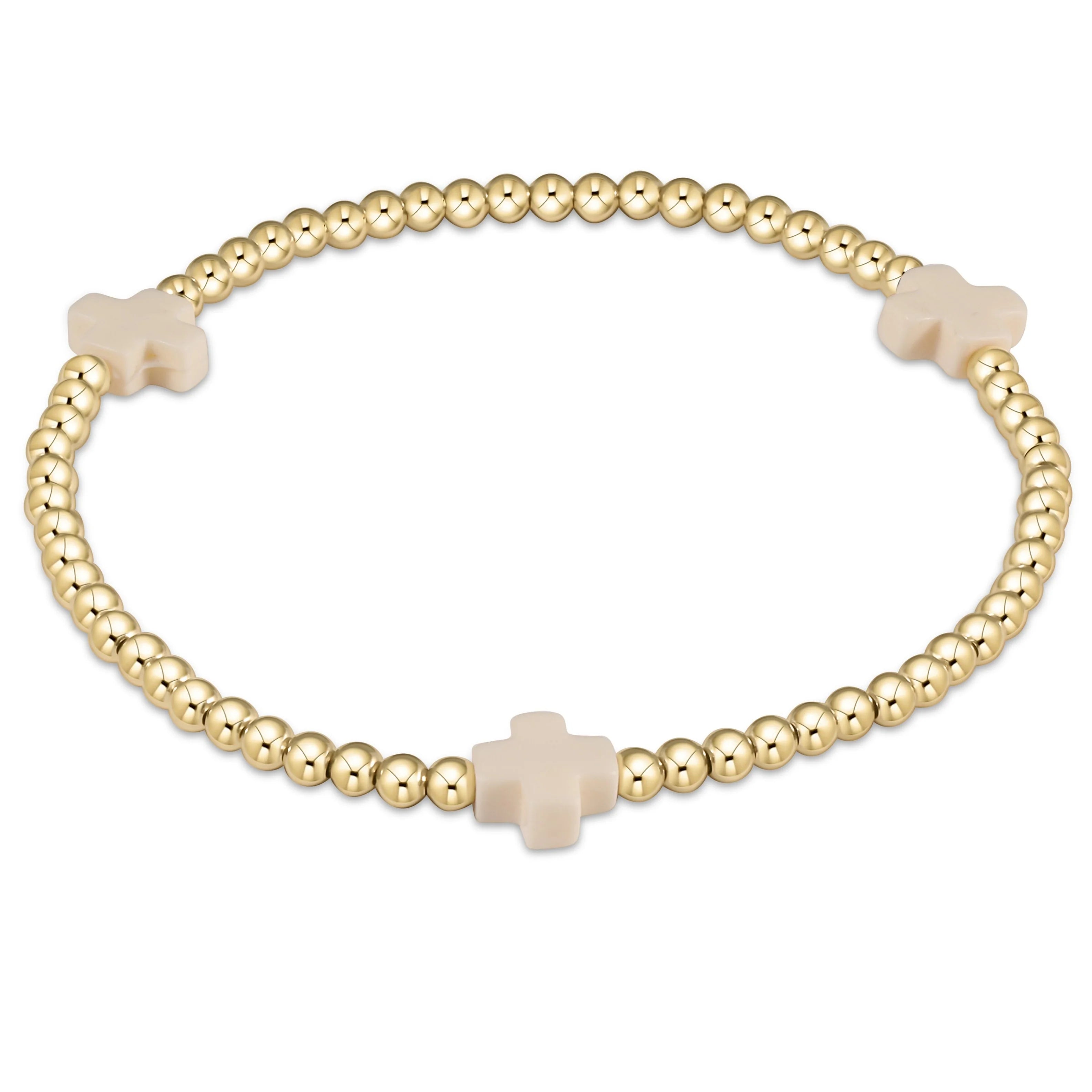 Gold beaded bracelet with off-white cross charm, clasped ends