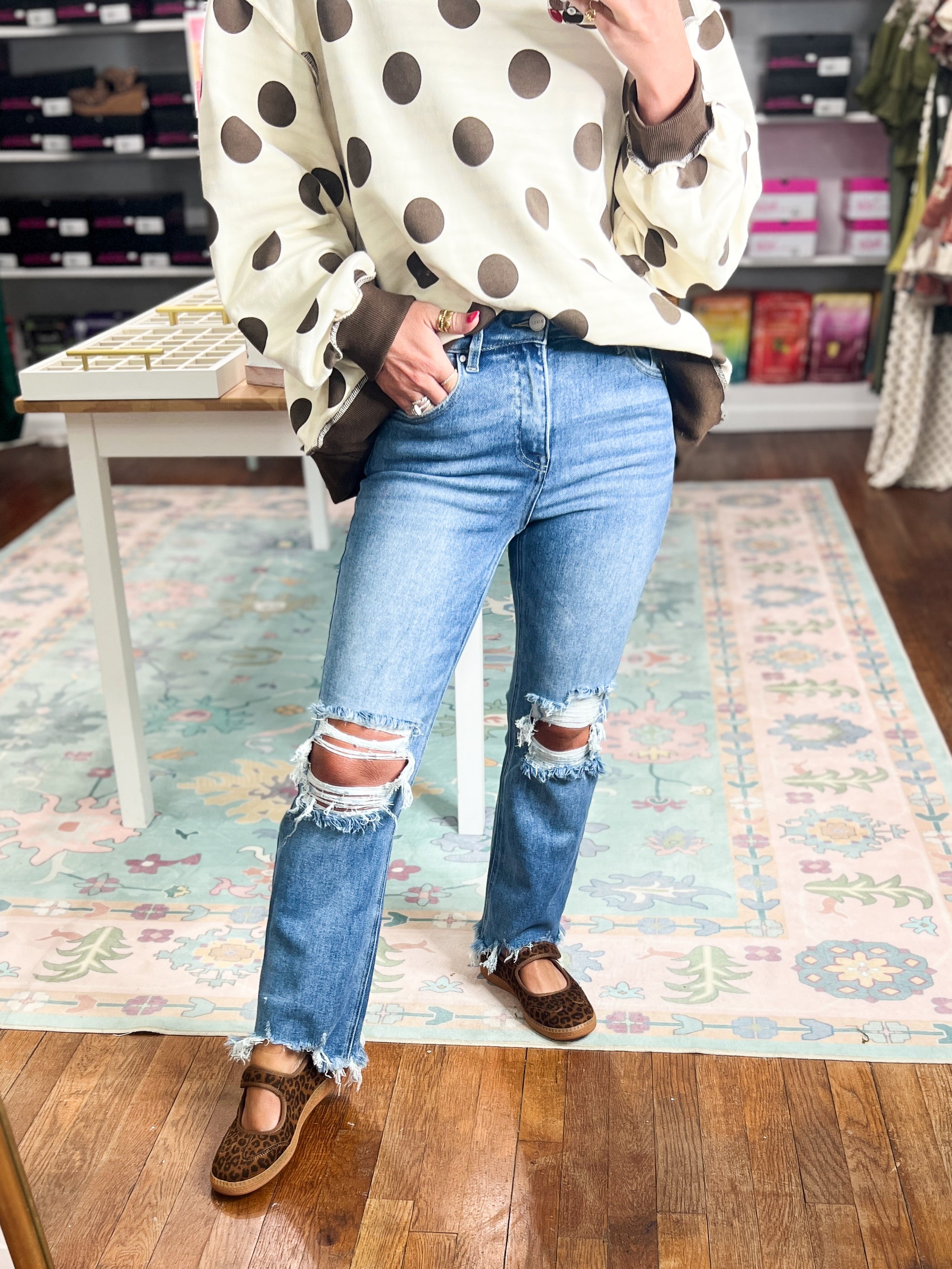 High-rise crop straight jeans in medium wash with ripped knees and frayed ankle hems