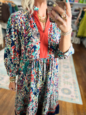 Floral tiered dress with V-neck, long sleeves, and red trim