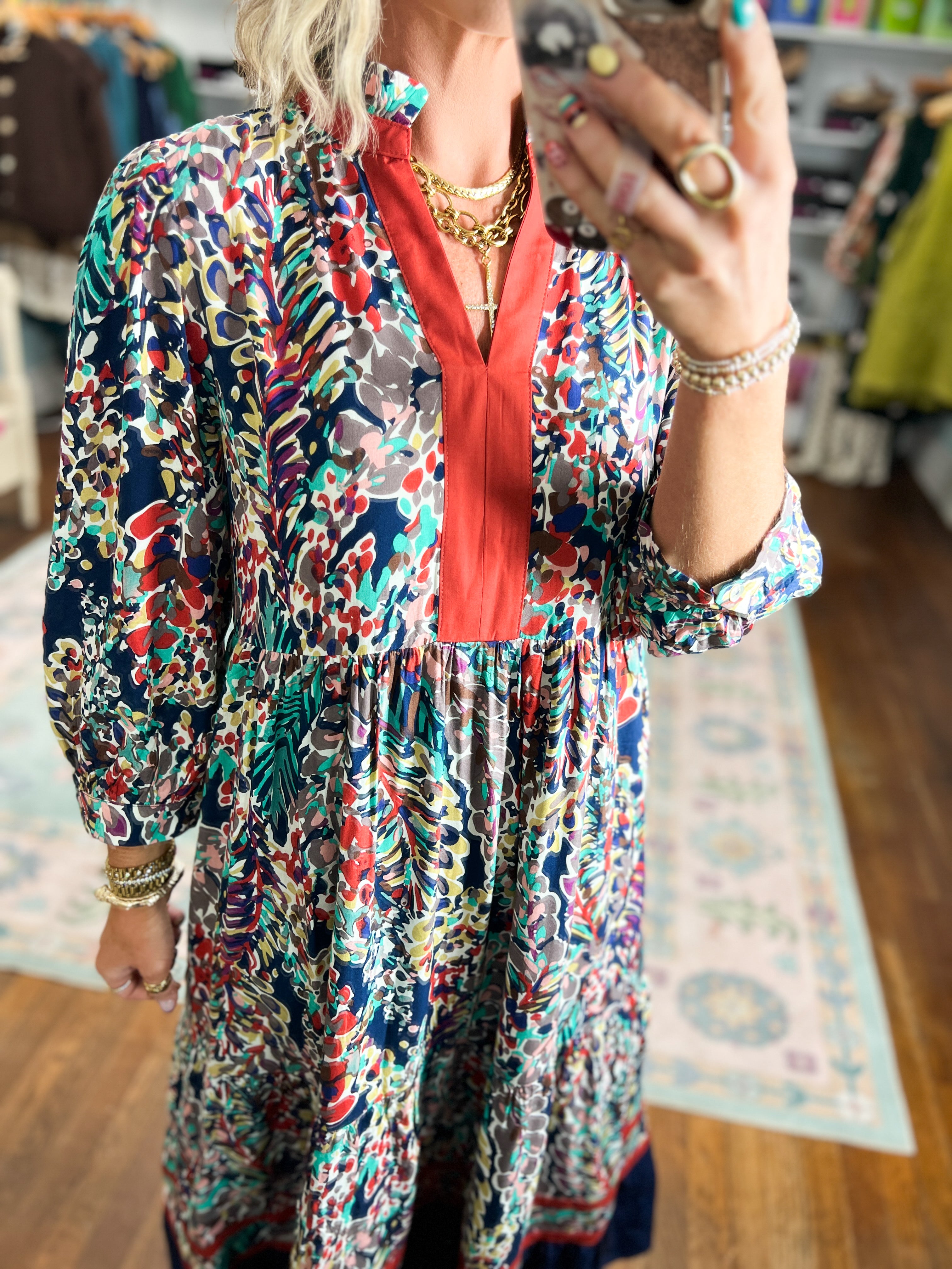 Floral tiered dress with V-neck, long sleeves, and red trim
