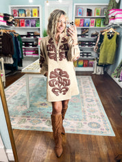 Taupe applique dress with long sleeves, floral front design, and buttoned neckline
