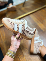 Side view of leopard-print mini sneakers with white laces and tan textured sole.