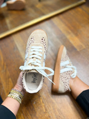 Mini sneakers with leopard-speckled toe and open collar, held for a top view.