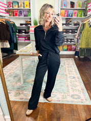 Black straight-leg elastic-waist pants with drawstring tie, full-body style