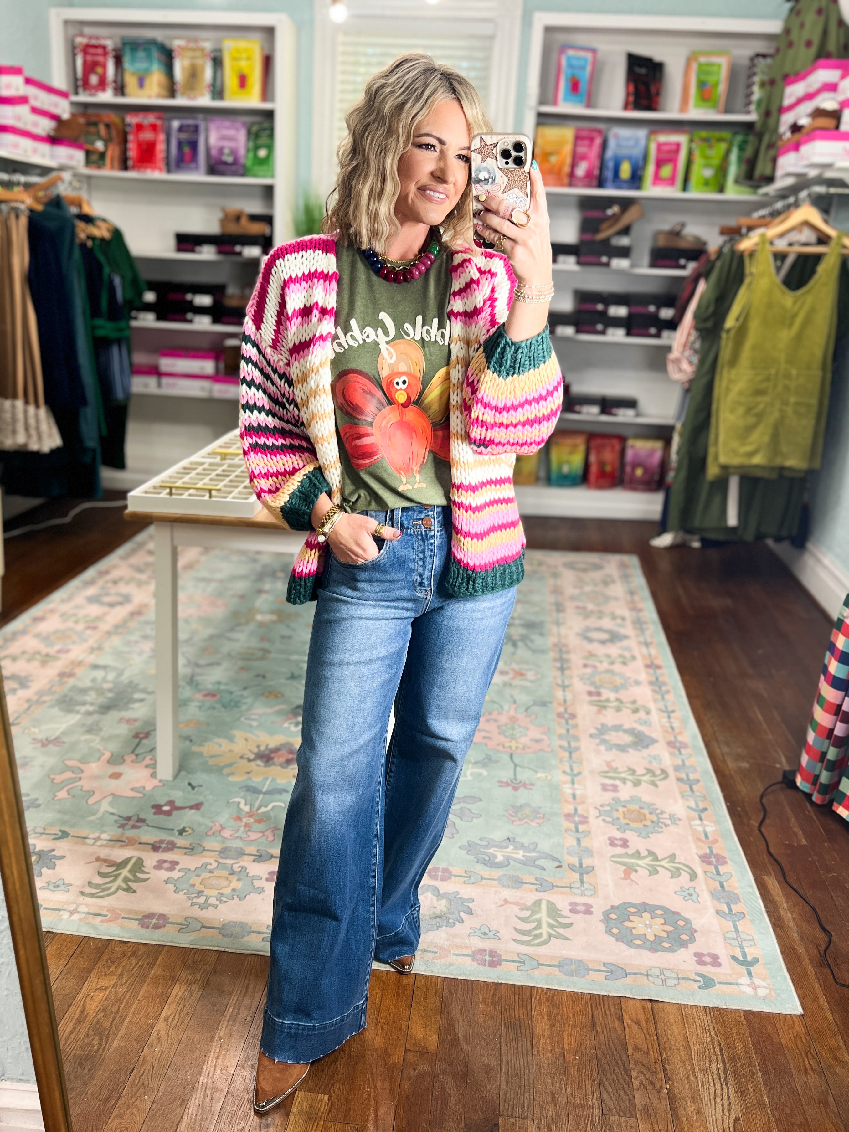 Multicolor striped knit cardigan with pink, cream, and teal stripes and long sleeves