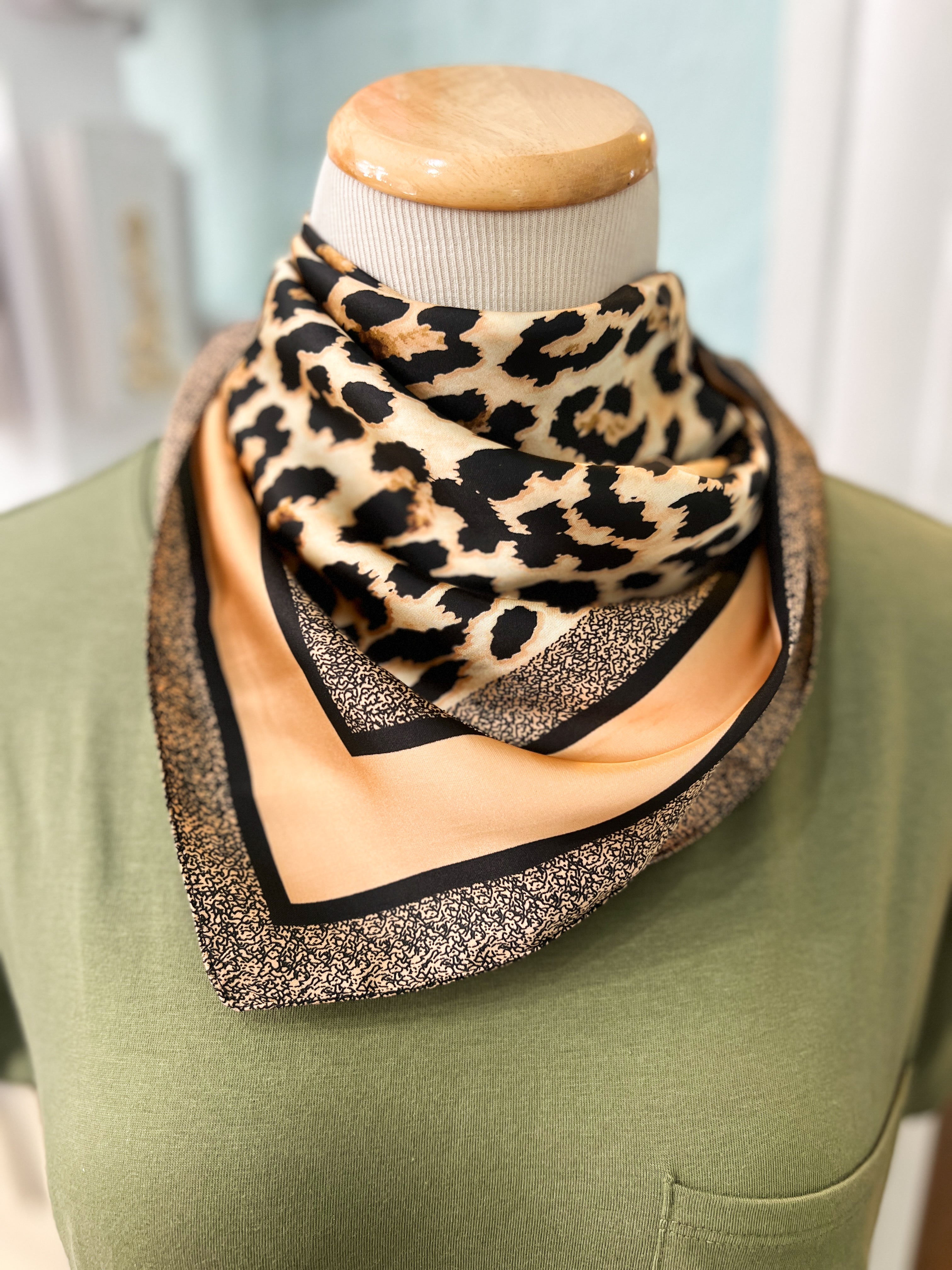 Silky bandana with leopard print in brown and black, framed by black and gold trim