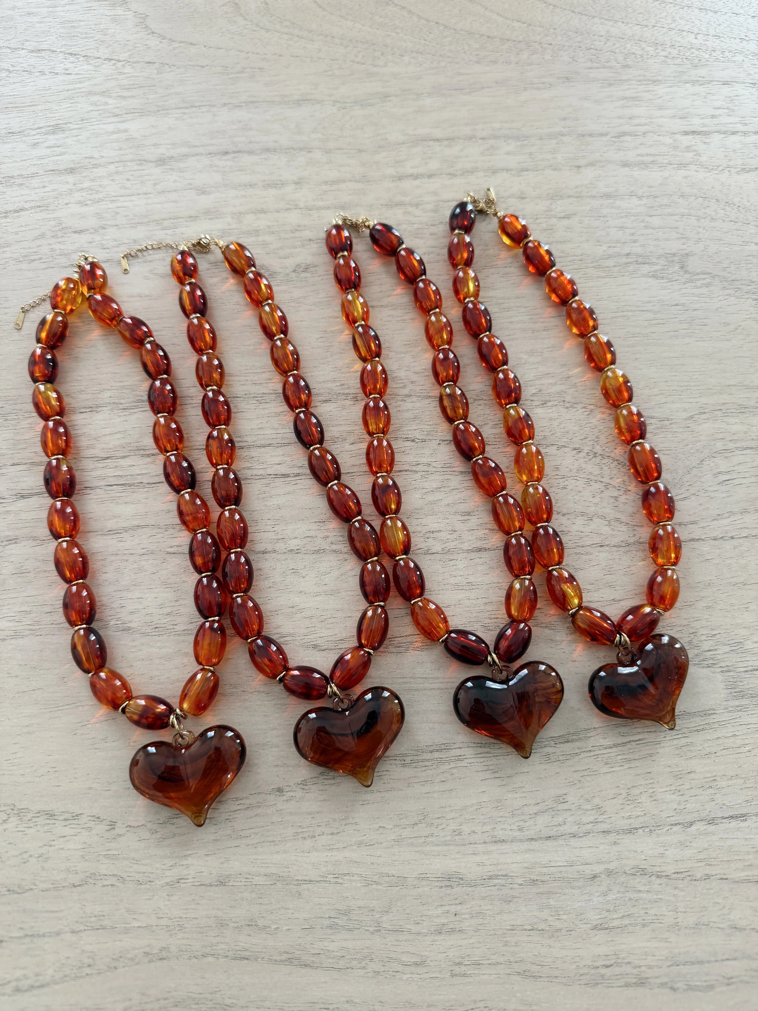 Layered amber bead necklace with three heart pendants